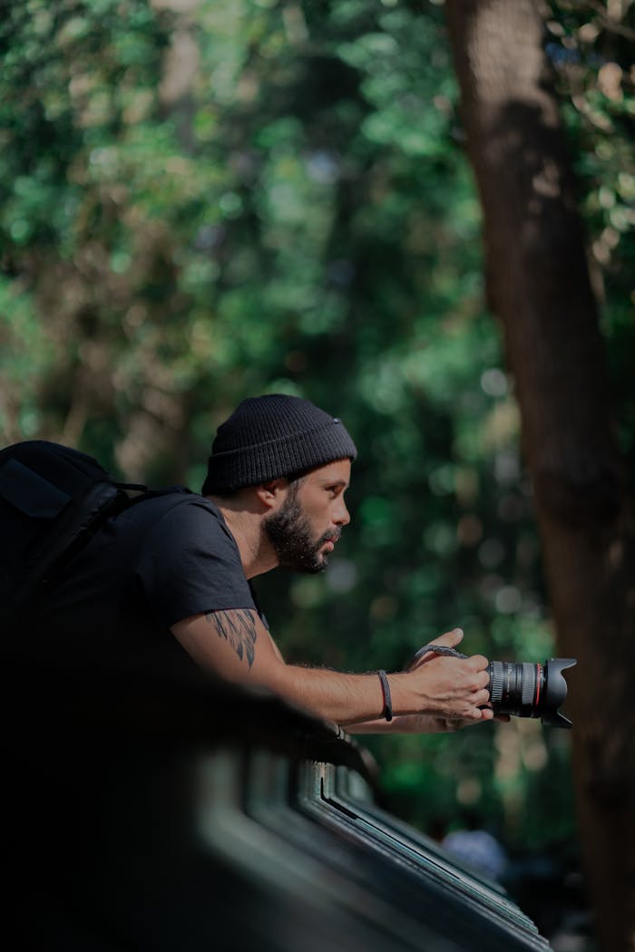 A focused man capturing the beauty of nature with a professional camera outdoors.
